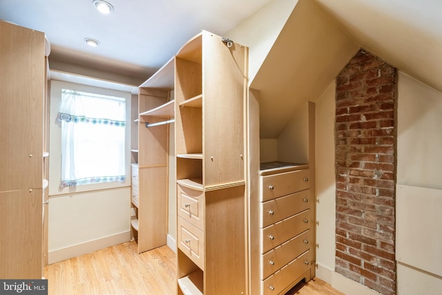 spacious closet with vaulted ceiling and light hardwood / wood-style floors