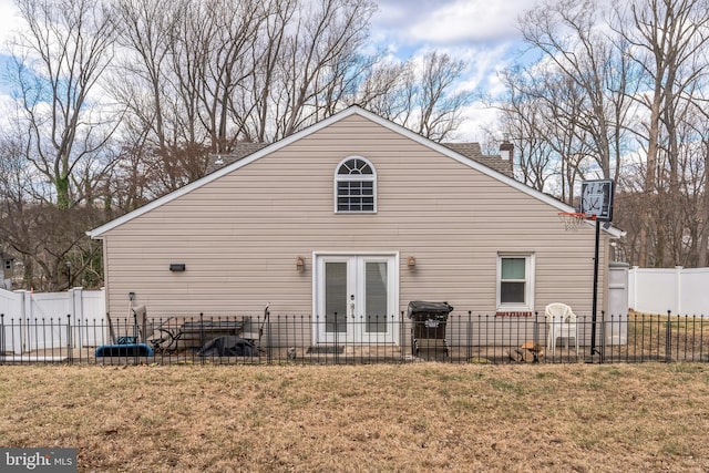 view of property exterior featuring french doors and a lawn