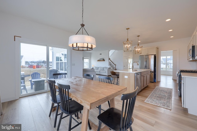 dining space with stairs, light wood finished floors, and recessed lighting