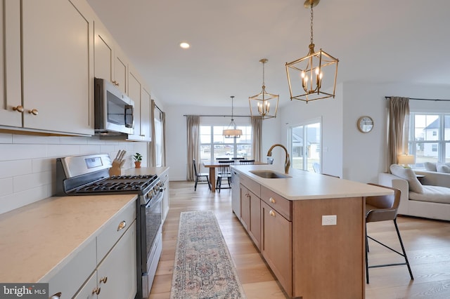 kitchen featuring light countertops, appliances with stainless steel finishes, a sink, and white cabinets