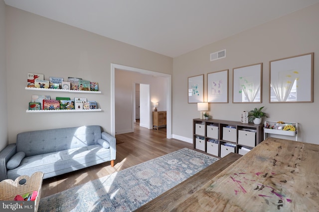 bedroom with wood finished floors, visible vents, and baseboards