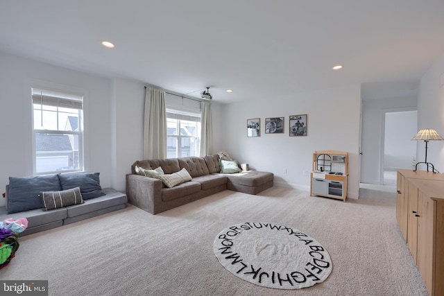 living area featuring recessed lighting, light carpet, and baseboards