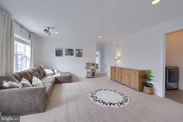 living area featuring washer / dryer, light colored carpet, and recessed lighting