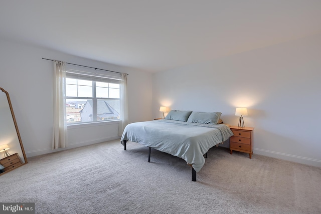 bedroom with light colored carpet and baseboards