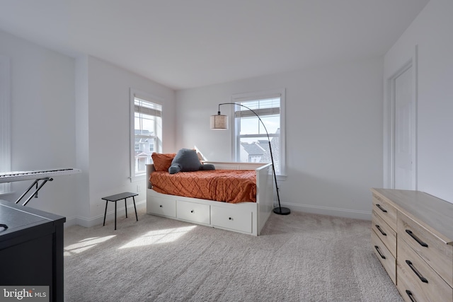 bedroom with baseboards and light colored carpet