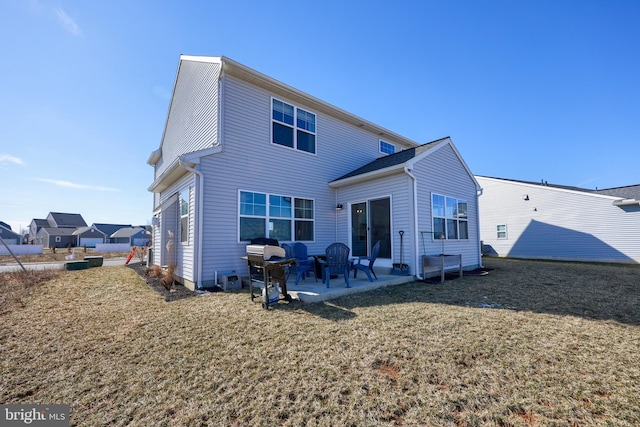 back of property with a lawn and a patio