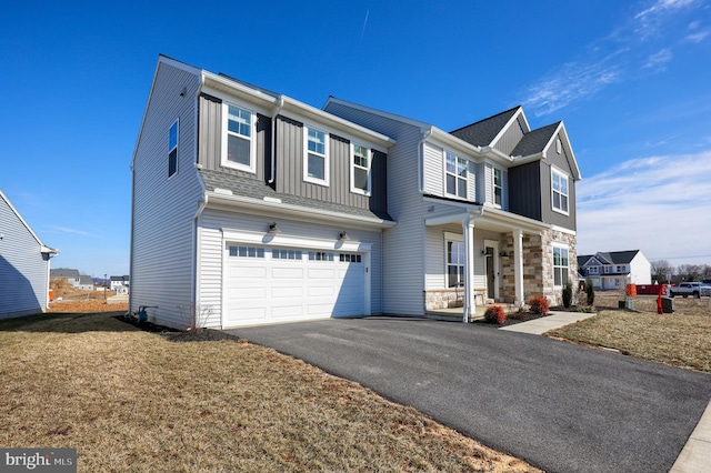 view of front facade featuring board and batten siding, stone siding, driveway, and an attached garage