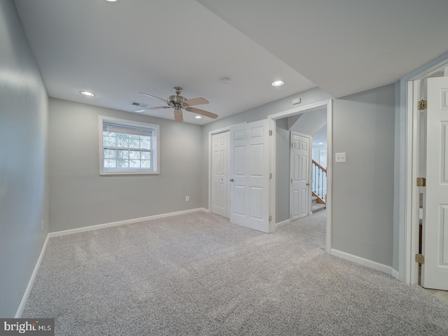 unfurnished room with light carpet, visible vents, baseboards, and recessed lighting