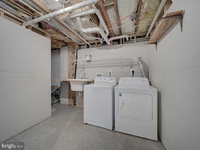 laundry room featuring laundry area, light floors, a sink, and washer and dryer