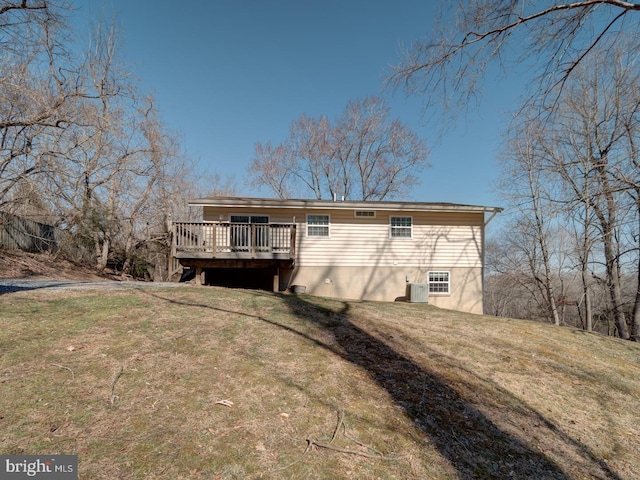 rear view of property featuring a wooden deck and a yard