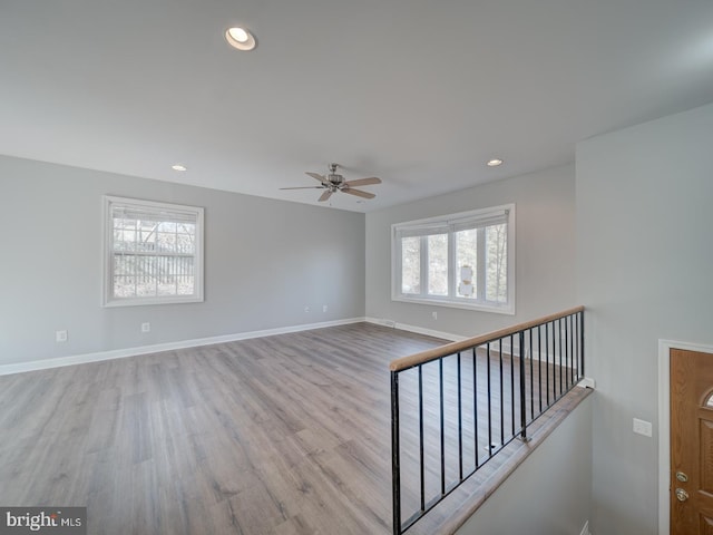 empty room with baseboards, light wood-style floors, and recessed lighting