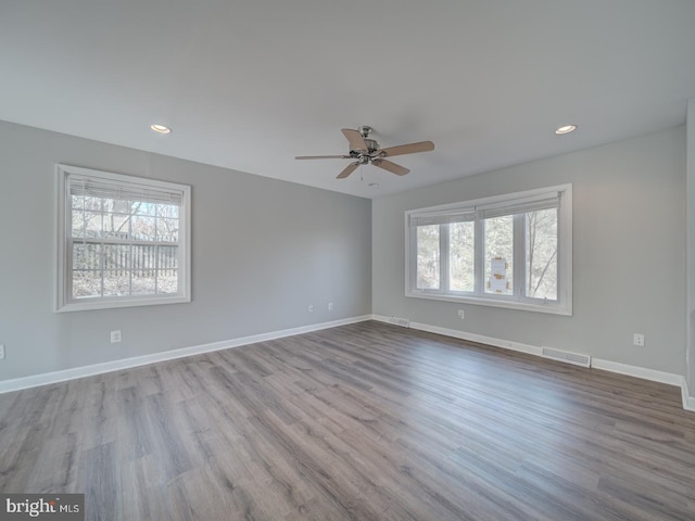 unfurnished room featuring light wood finished floors, recessed lighting, visible vents, and baseboards