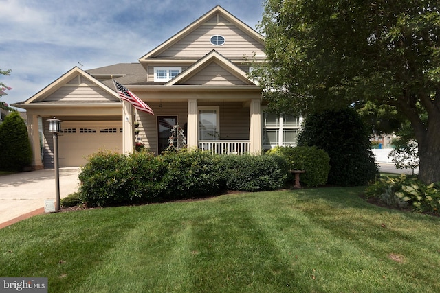 view of front of house featuring a garage, a front yard, and covered porch