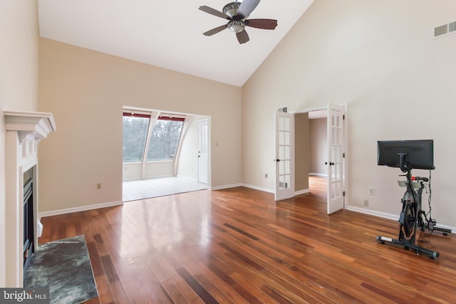 unfurnished living room featuring dark wood-type flooring, ceiling fan, high vaulted ceiling, and french doors