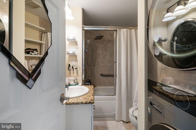 full bath featuring visible vents, toilet, shower / bath combo with shower curtain, vanity, and stacked washing maching and dryer