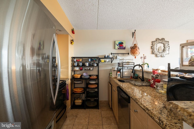 kitchen featuring a textured ceiling, light tile patterned flooring, a sink, freestanding refrigerator, and dishwasher