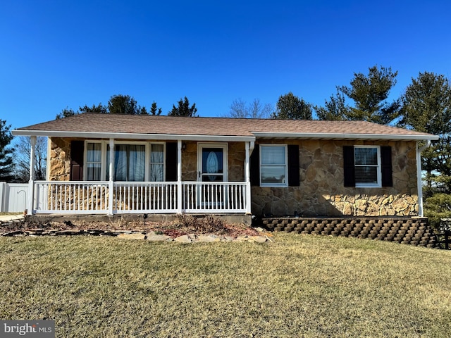 single story home featuring stone siding, a front lawn, and a porch