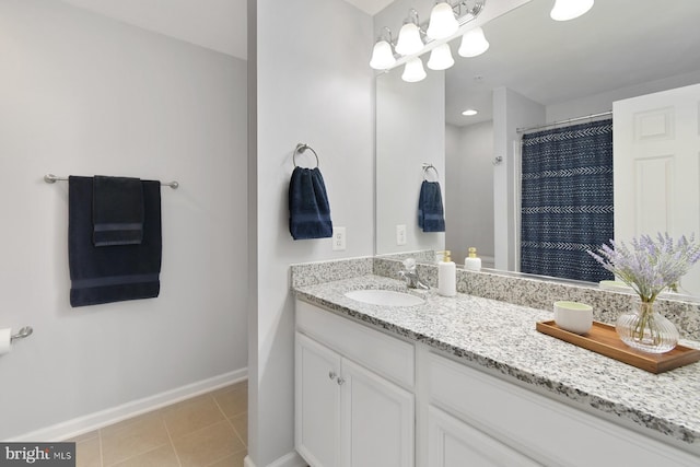 bathroom with tile patterned flooring, vanity, and walk in shower