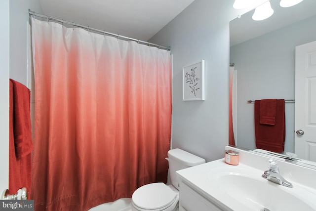 bathroom featuring a shower with curtain, vanity, and toilet