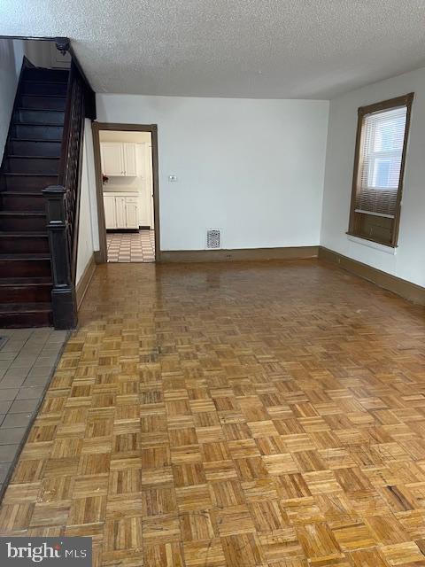 empty room featuring light parquet flooring and a textured ceiling