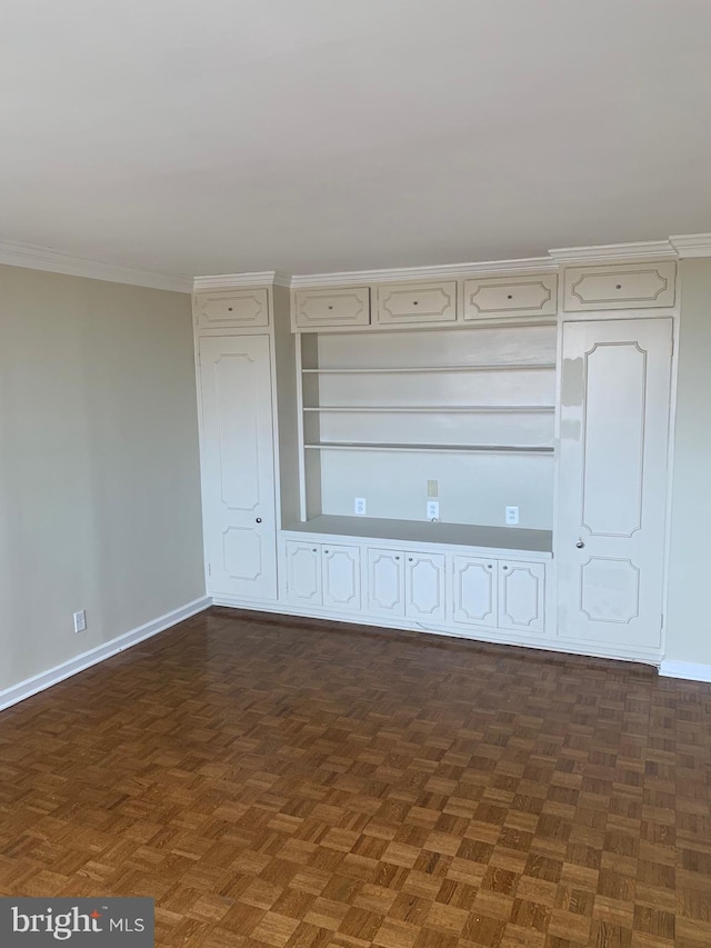 spare room with baseboards and ornamental molding