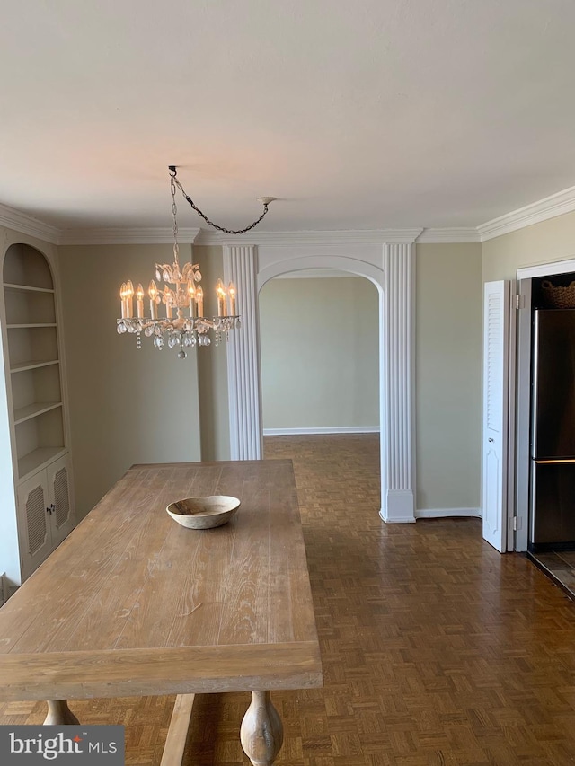 unfurnished dining area featuring arched walkways, an inviting chandelier, baseboards, and crown molding