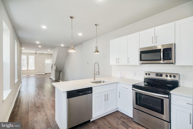 2941 Cecil B Moore Ave, Philadelphia, PA 19121 - kitchen with stainless steel appliances, white cabinets, a peninsula, dark wood-style flooring, and recessed lighting