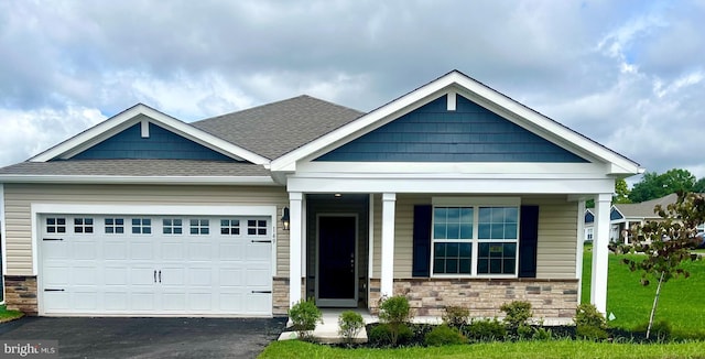 craftsman inspired home featuring stone siding, aphalt driveway, roof with shingles, an attached garage, and a porch