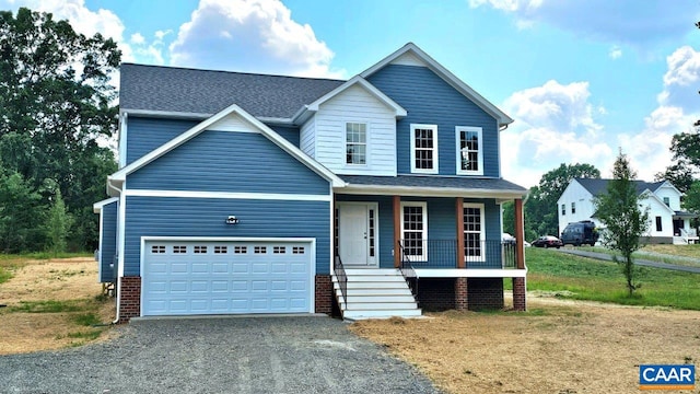 view of front of house featuring a garage, a front lawn, and covered porch