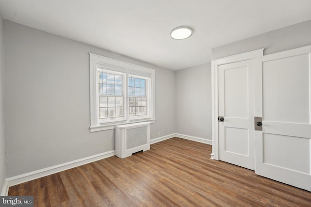 interior space with hardwood / wood-style floors and radiator heating unit