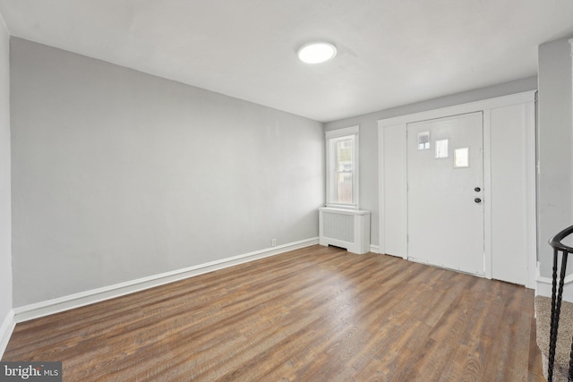 entrance foyer with radiator heating unit and dark hardwood / wood-style floors