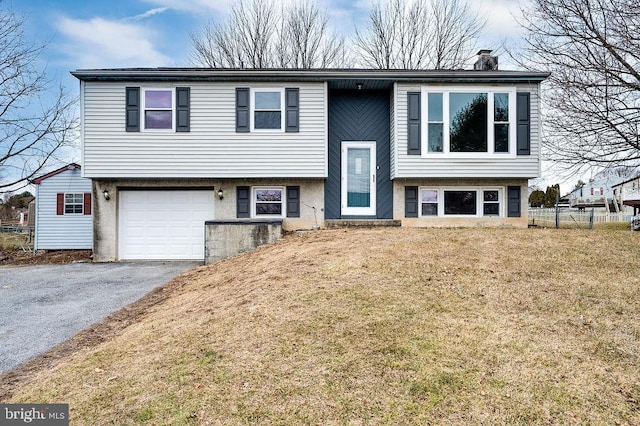 bi-level home with a garage and a front lawn