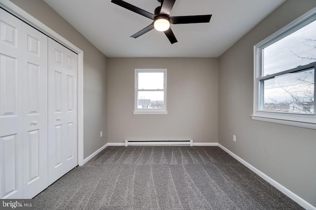 unfurnished bedroom with a baseboard radiator, carpet, ceiling fan, and a closet