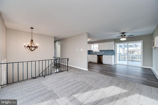 spare room with dark hardwood / wood-style flooring and ceiling fan with notable chandelier