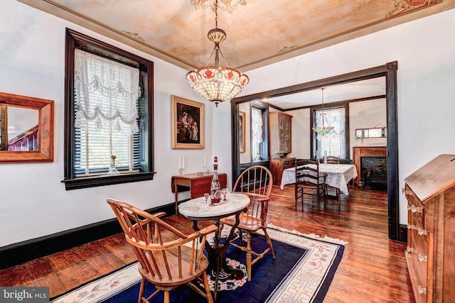 dining area featuring an inviting chandelier, ornamental molding, and hardwood / wood-style floors