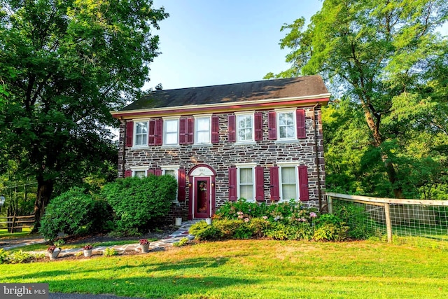 colonial home featuring a front lawn