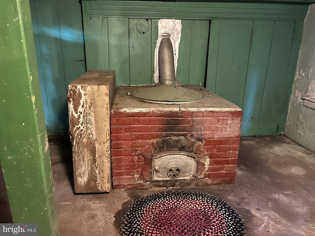 interior details featuring concrete flooring and a wood stove