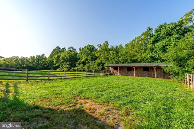 view of yard with an outdoor structure and a rural view