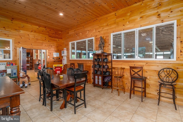 dining space with wood ceiling, wooden walls, and light tile patterned flooring