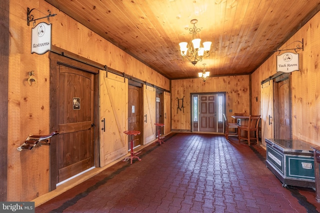 entrance foyer featuring wood ceiling, a chandelier, and wood walls