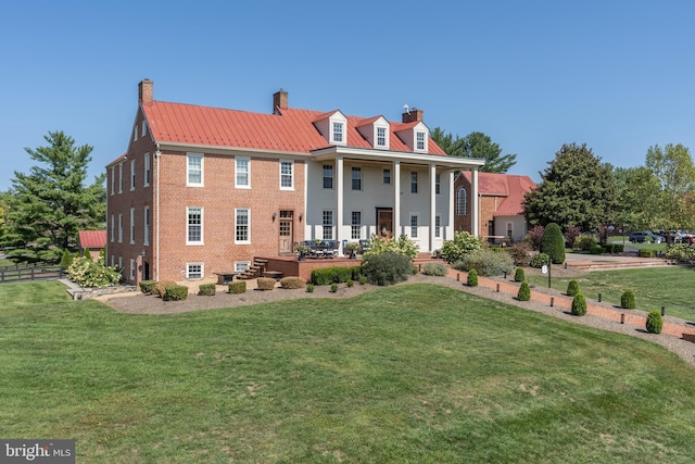 rear view of property with a porch and a lawn