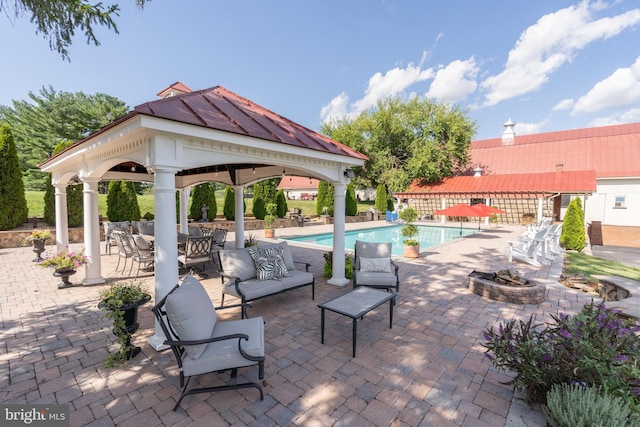 view of swimming pool featuring a gazebo, an outdoor living space with a fire pit, and a patio