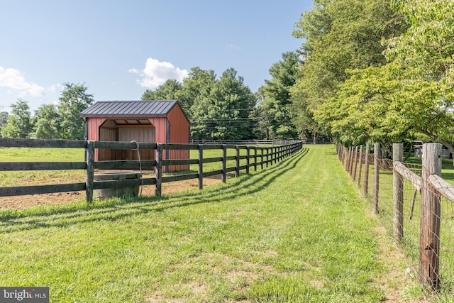 view of yard featuring a rural view and an outbuilding