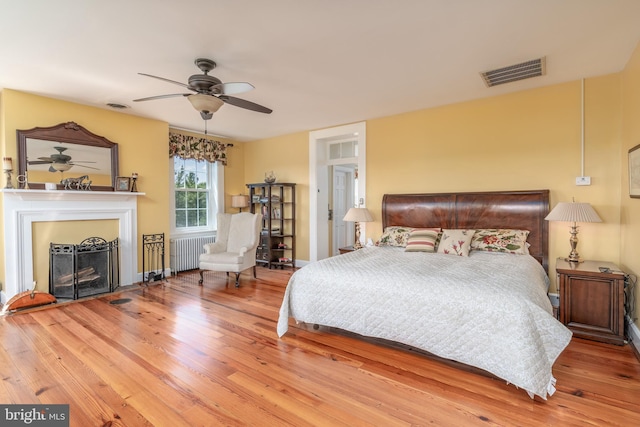 bedroom featuring ceiling fan, radiator, and light wood-type flooring