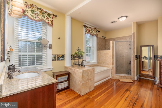 bathroom with vanity, wood-type flooring, and independent shower and bath