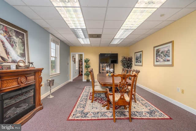 dining space featuring a drop ceiling and carpet floors