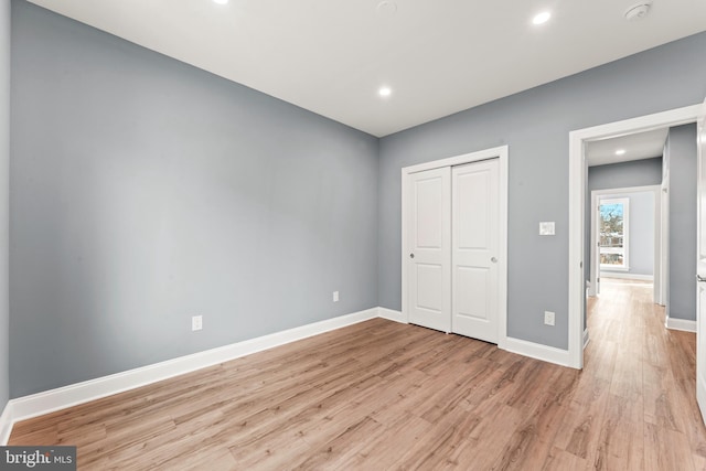 unfurnished bedroom with a closet and light wood-type flooring