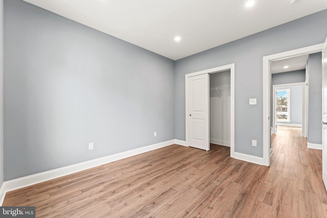 unfurnished bedroom with a closet and light wood-type flooring