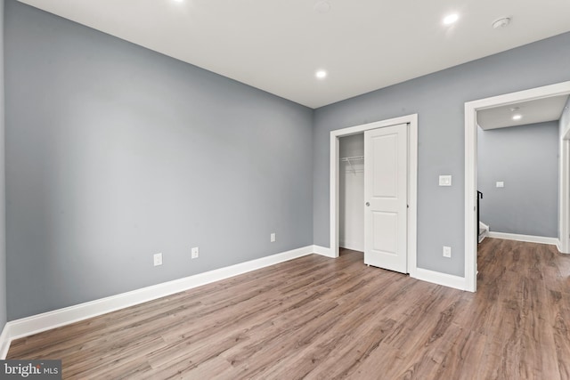 unfurnished bedroom featuring a closet and light hardwood / wood-style flooring