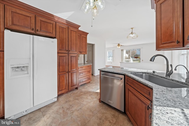 kitchen with sink, white refrigerator with ice dispenser, stainless steel dishwasher, ceiling fan, and light stone counters